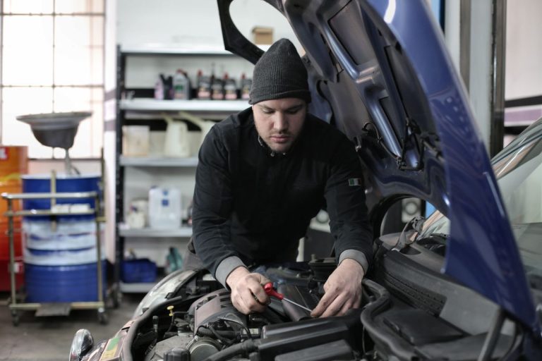 Técnico inspecionando o motor de um veículo com kit GNV durante vistoria