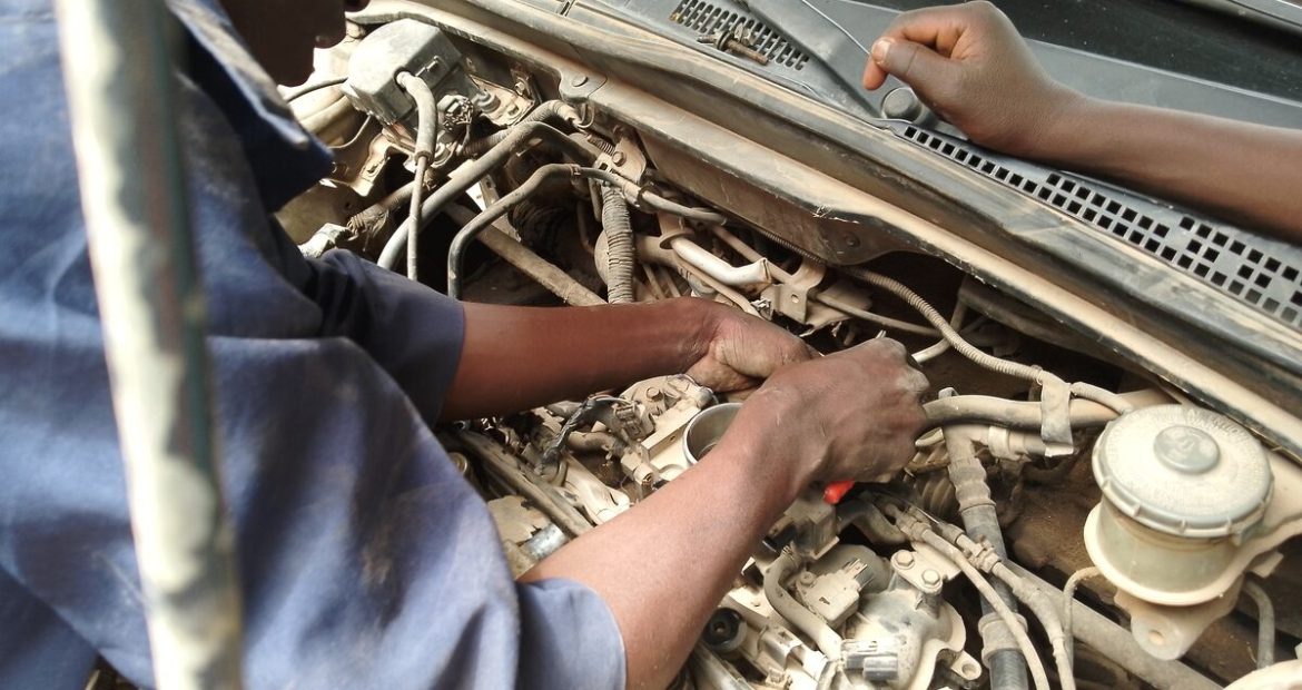 Mecânico inspecionando o motor de um carro em busca de defeitos ocultos