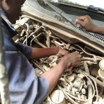 Mecânico inspecionando o motor de um carro em busca de defeitos ocultos