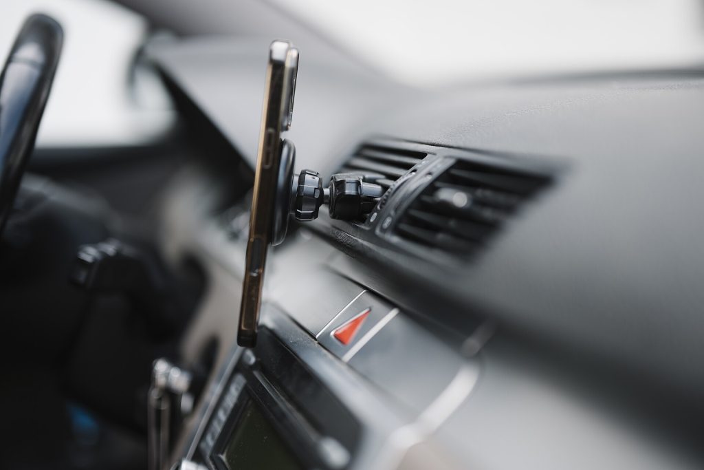 Smartphone com navegação GPS no painel do carro a caminho da vistoria veicular